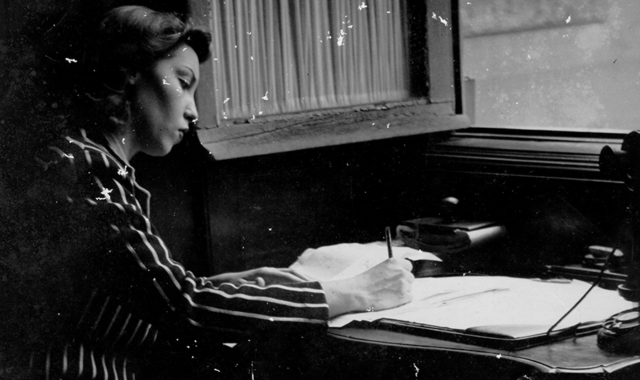 Uma foto de Clarice Lispector escrevendo.