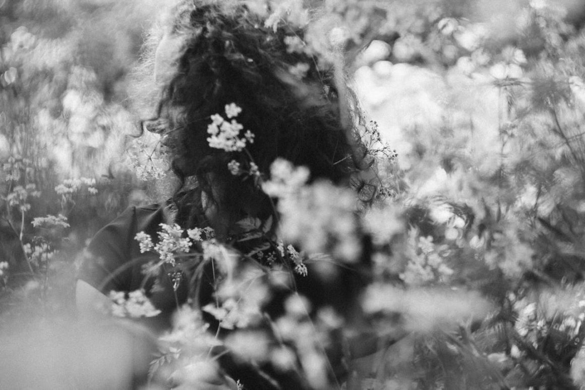 Um foto reflexiva de uma mulher em um campo de flores